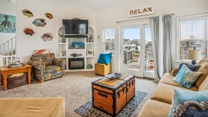 A cozy living room with a fireplace, a television, and a sign that reads "RELAX".