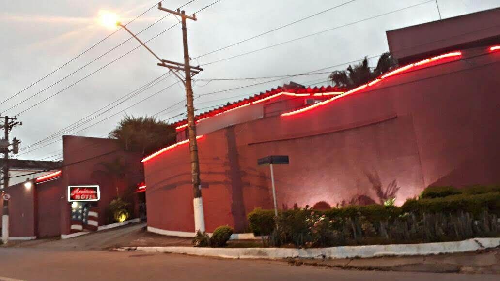A building with a red facade, a sign for a motel, and a streetlight.