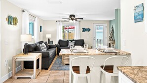 Un espacio habitable compacto con comedor, sofá, mesa de centro y ventilador de techo.