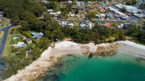 An aerial view of a coastal residential area with houses, roads, and a beach. - Vincentia Breeze by Experience Jervis Bay (Vincentia)