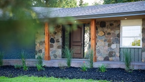 A stone house with a wooden porch and a door.