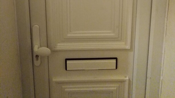 A white door with a traditional design, including a knocker and a mail slot. - London Airport Comfort (London)