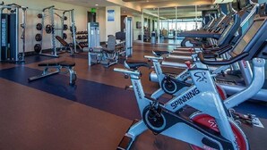 Ett gym med motionscyklar, styrketräningsmaskiner och lösa vikter.