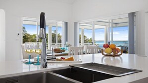 Een moderne keuken met een groot raam, een inbouwspoelbak en een fruitschaal op het aanrecht.