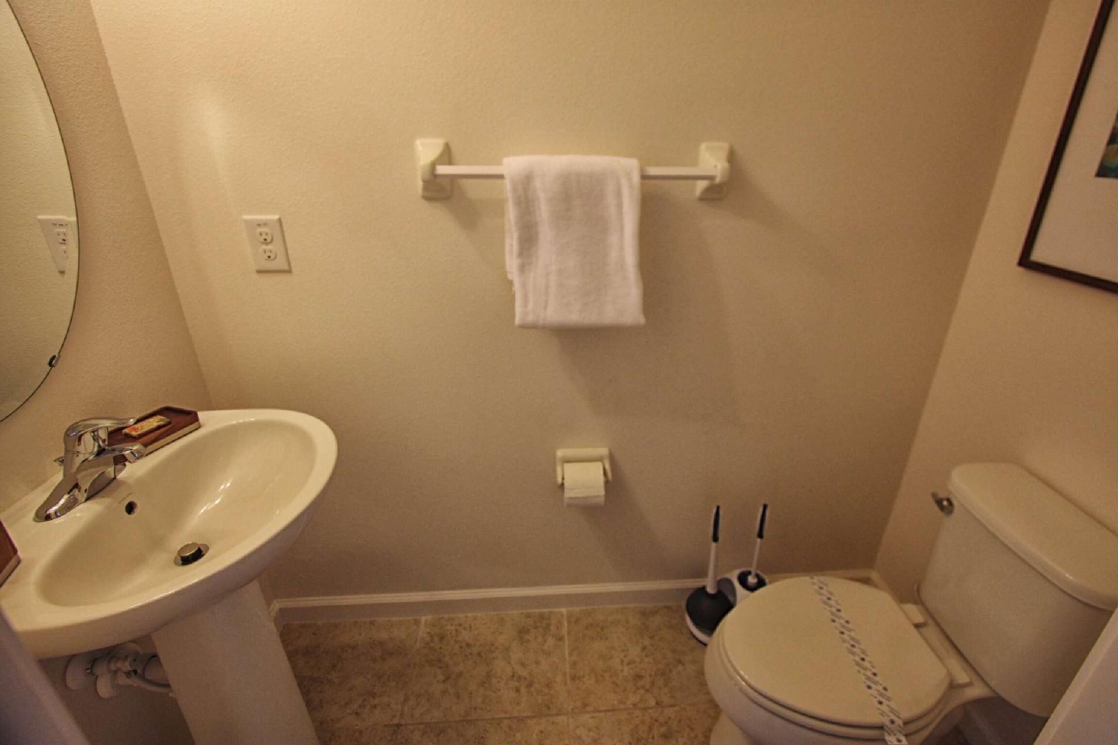 A bathroom with a sink, toilet, and towel rack.
