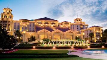 Un hotel grande y lujoso, con una entrada imponente y un jardín cuidado.