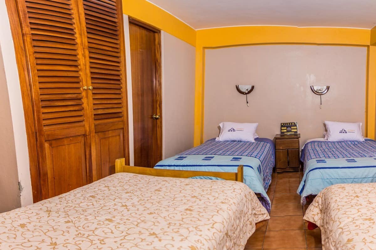 Ein Zimmer mit zwei Betten, einem Holzschrank und einem Willkommensschild.