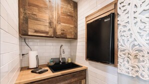 A kitchen with white tiled walls, a wooden countertop, a black sink, and a refrigerator. - Private Studio , spectacular  Ocean View , bathroom , kitchenette, Very Quiet (Half Moon Bay)