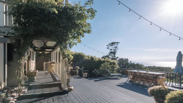 A wooden deck with outdoor furniture, a pergola with climbing plants, and a view of the landscape. - Private Studio , spectacular  Ocean View , bathroom , kitchenette, Very Quiet (Half Moon Bay)