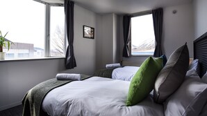 A hotel room with two beds, a large window, and a view of the outdoors. - The Phat Packers - Hostel (Otari)