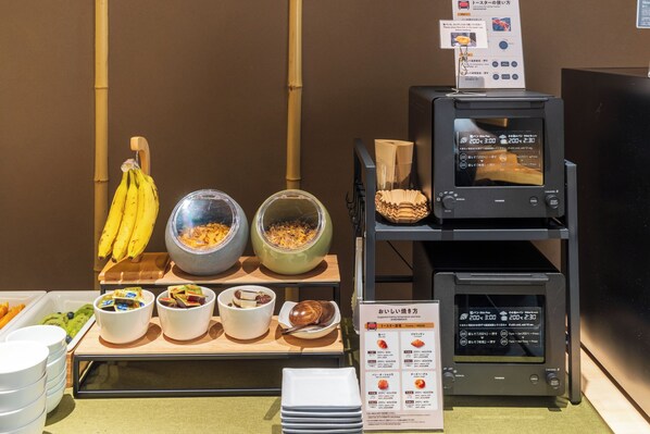 A buffet setup with various food items and a toaster oven.