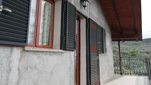 Ein Gebäude mit einer Betonfassade, Holzbalken und einem Balkon mit Metallgeländer.