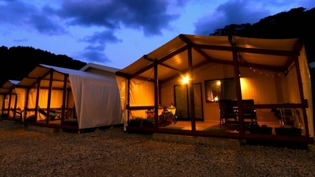 A series of tents with a covered outdoor area, a seating arrangement, and a visible entrance.