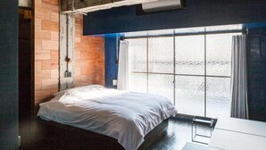 A bedroom with a bed, a window with curtains, and a wooden wall. - Area Inn Fushimicho Fukuyama Castle Side 2-8 - Hostel (Fukuyama)