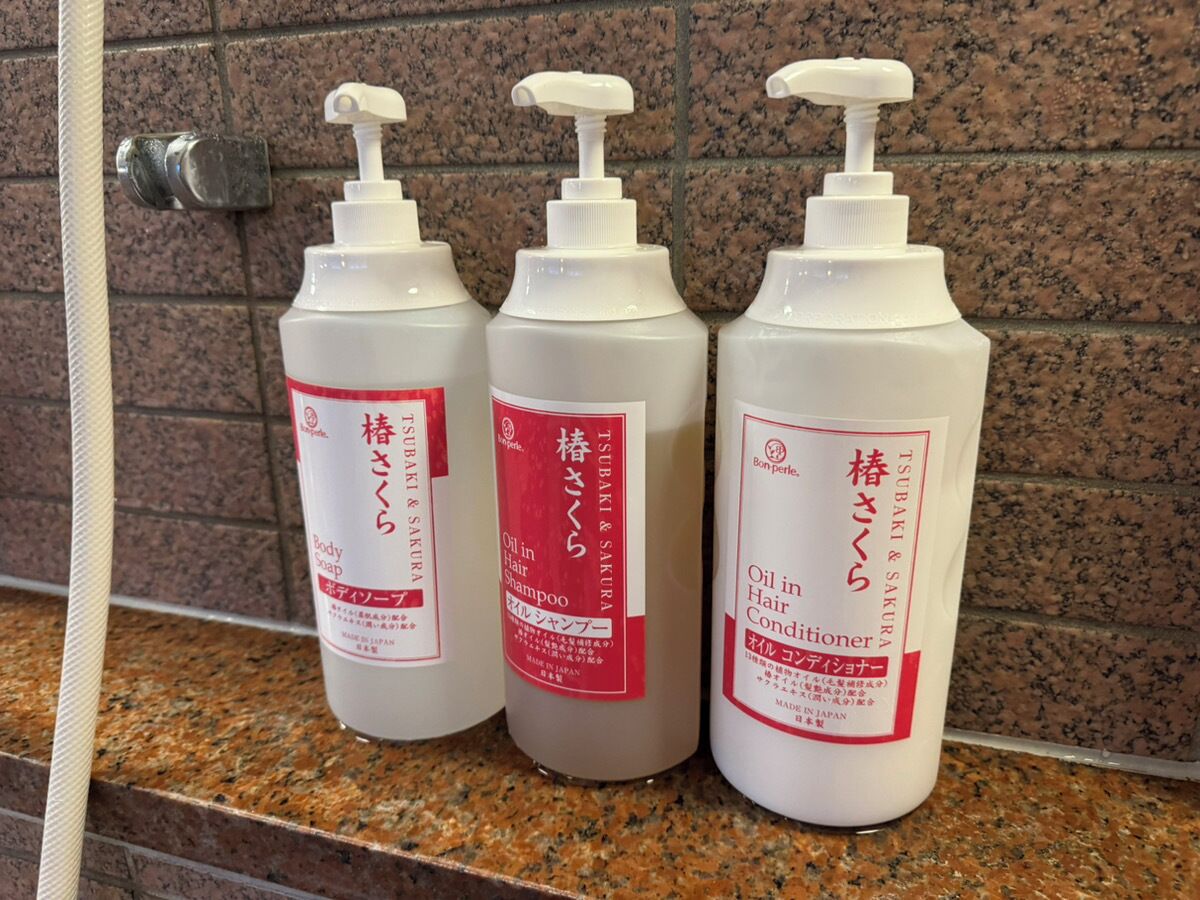Three bottles of hair care products on a granite countertop.