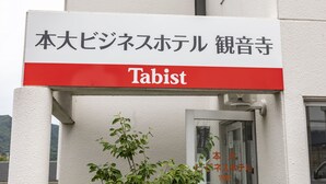Un letrero para un hotel llamado "Tabist", con texto en japonés en la parte superior y texto en inglés en la parte inferior.
