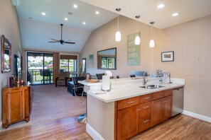 Enjoy a spacious interior with a high ceiling, central kitchen island, and dining area with a view.