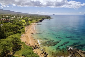 Relax in a serene coastal setting surrounded by lush greenery and turquoise waters.