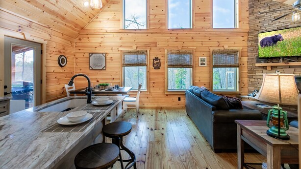 A cozy cabin interior with a kitchen, dining area, and living room.