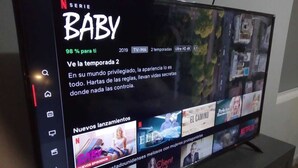 Een tv-scherm toont de Netflix-interface, waarbij de serie 'BABY' is uitgelicht met een aanbevelingspercentage van 98%.