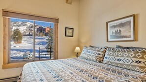 A bedroom with a large bed, a window with a view of a snowy landscape, and a framed picture on the wall. - ⭐️ 2 Level Unit w/ Pool ⎮Hot Tubs ⎮Private Deck (Steamboat Springs)
