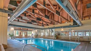 An indoor swimming pool with a wooden ceiling and visible structural beams. - Homey Hideaway Chalet in family friendly Tiger Run, mins from Breckenridge (Breckenridge)