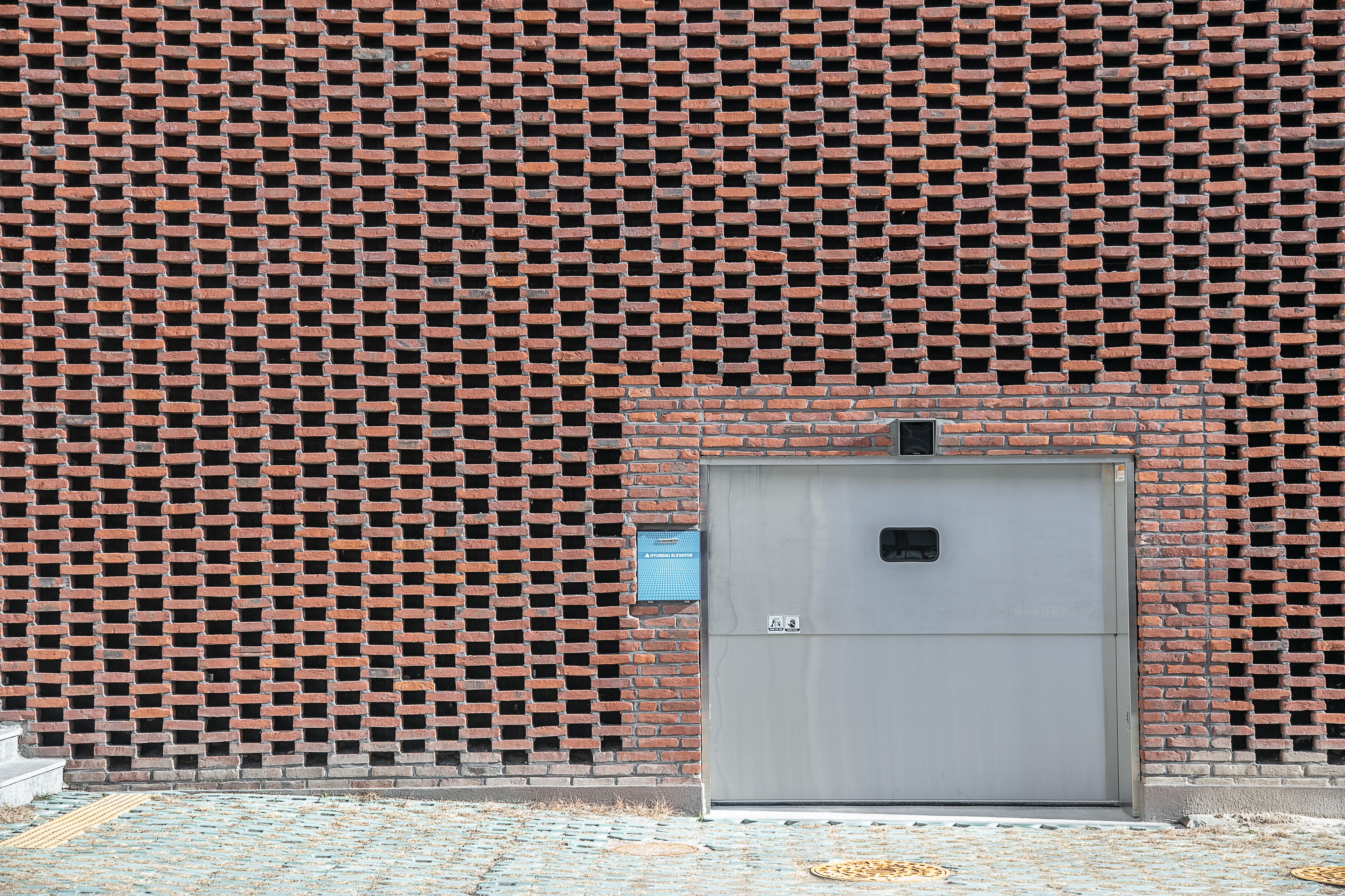 A building facade with a brick pattern and a metal door.