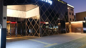 A hotel entrance with a modern glass facade and a sign reading "Lacozi Stay". - LACOZi STAY Seoul (Seoul)