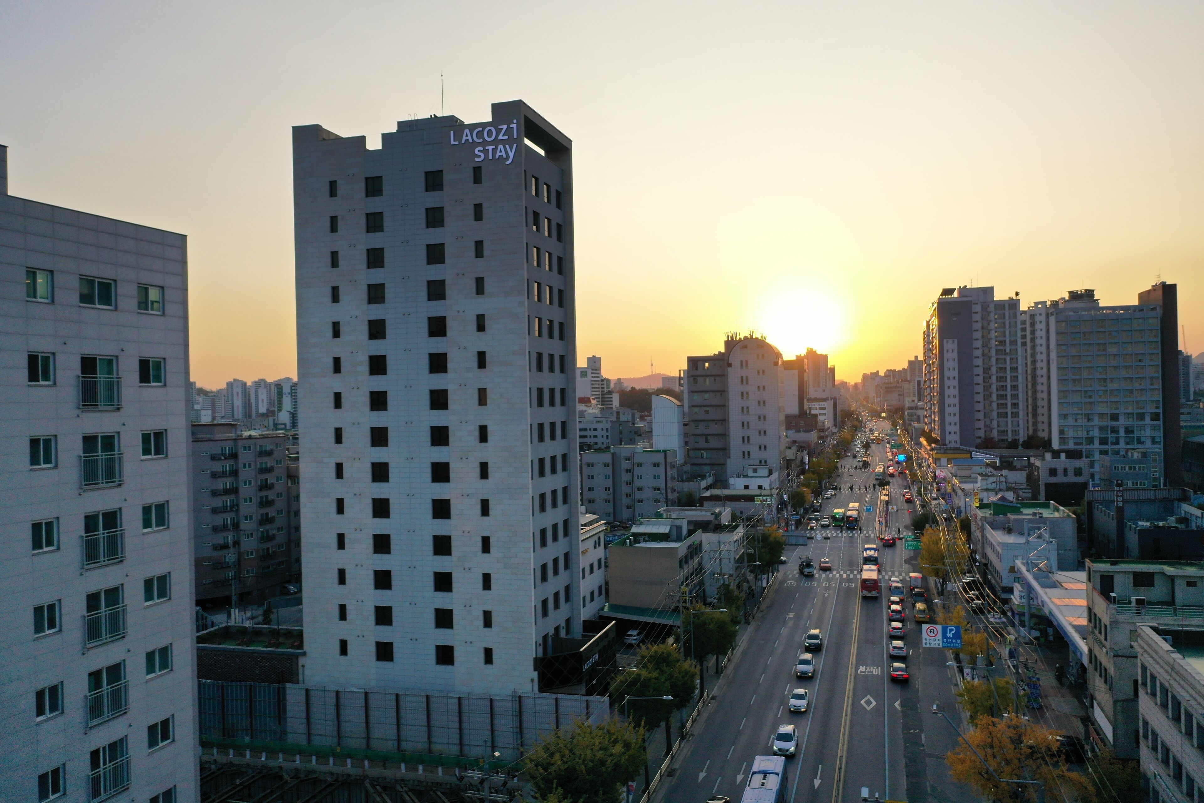 A high-rise hotel with a prominent sign, surrounded by a cityscape and a busy street.