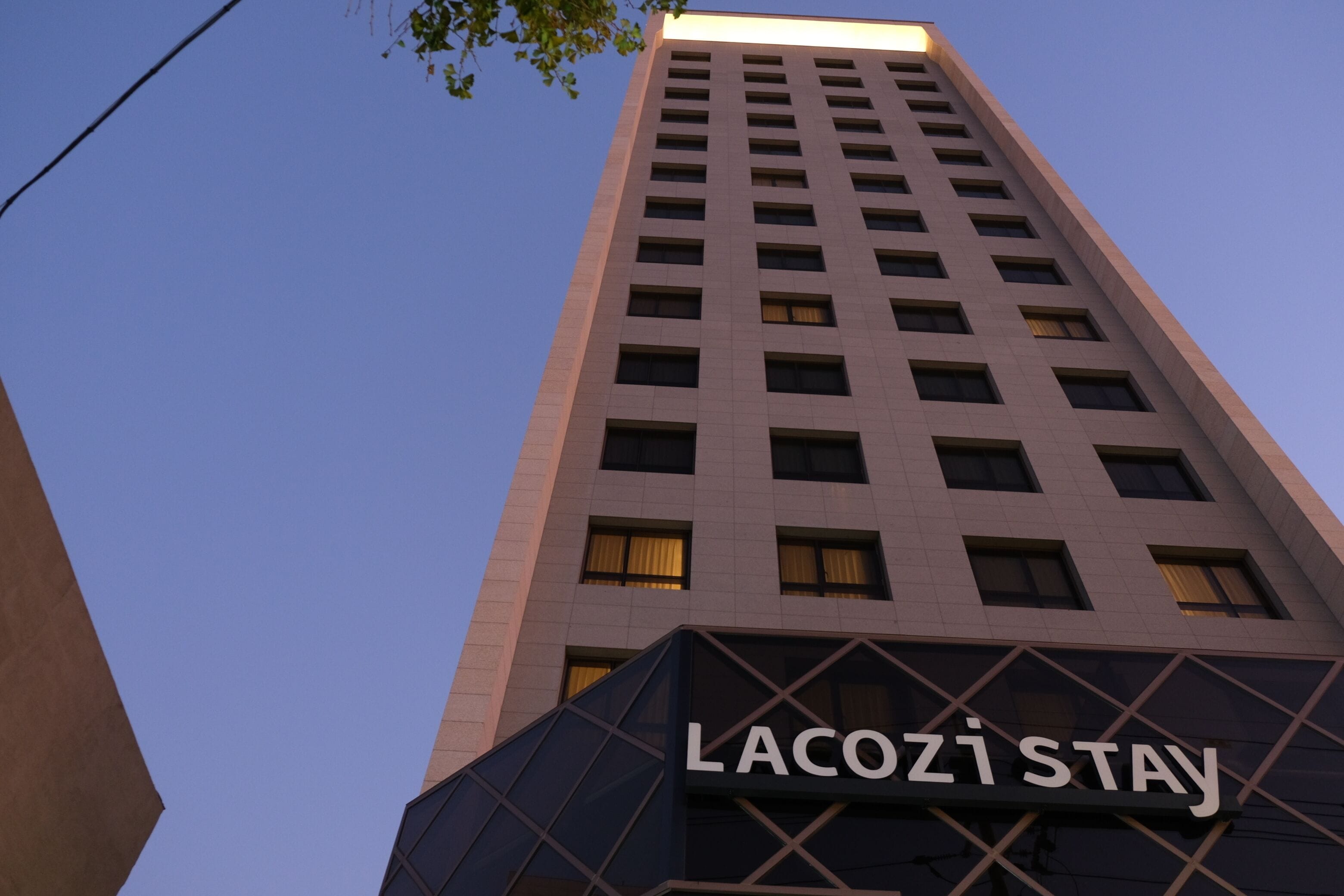 Un edificio alto con il cartello "LACOSI STAY" in basso.