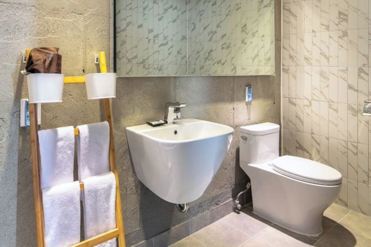 A bathroom with a sink, toilet, and towel rack.