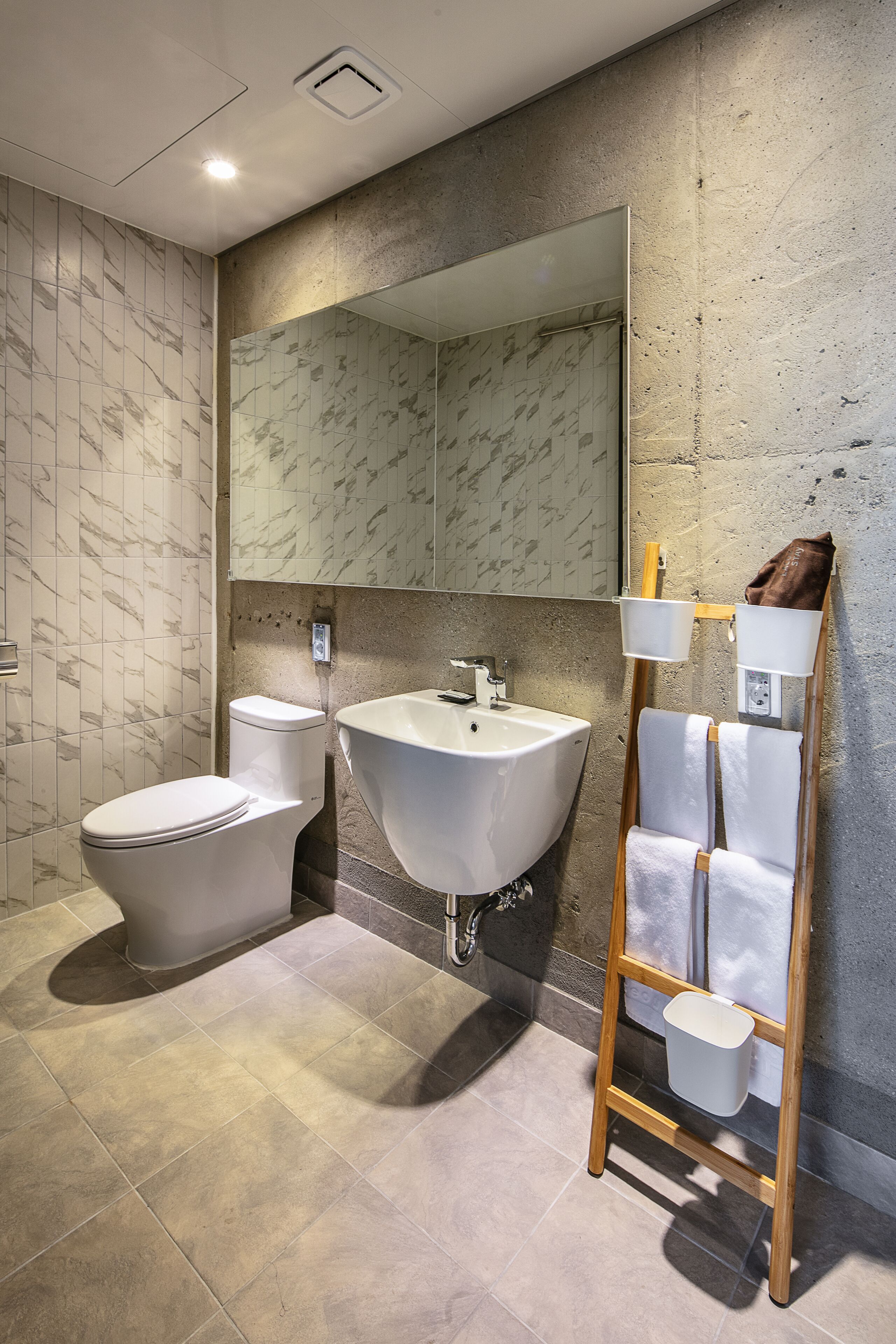 Une salle de bain moderne avec des toilettes, un lavabo et un miroir.