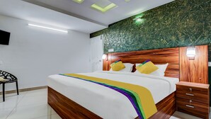 A modern bedroom with a wooden bed frame, a green marble wall, and a white ceiling with recessed lighting. - Itsy Hotels Dew Dreams (Aluva)