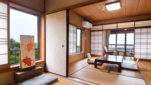 A traditional Japanese room with tatami flooring, a low table, and sliding doors. - Misaki Kanko Hotel (Muroto)