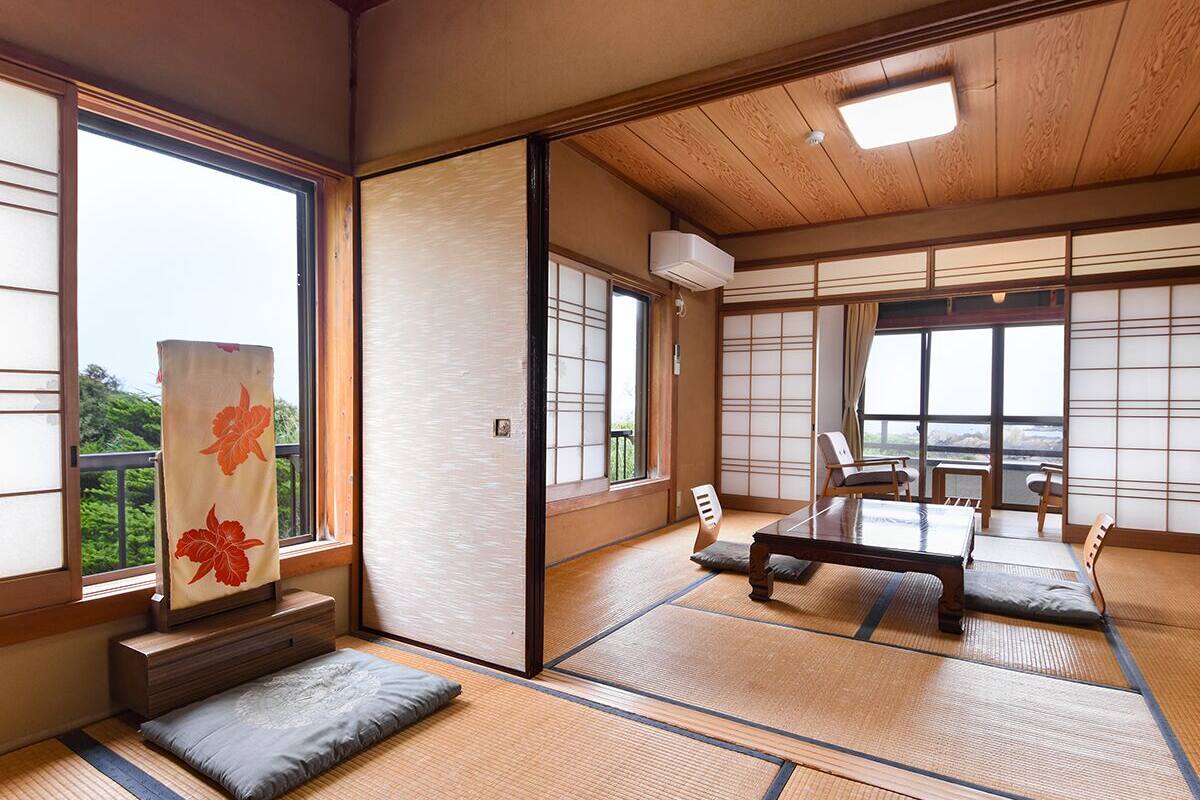 A traditional Japanese room with tatami flooring, a low table, and sliding doors.