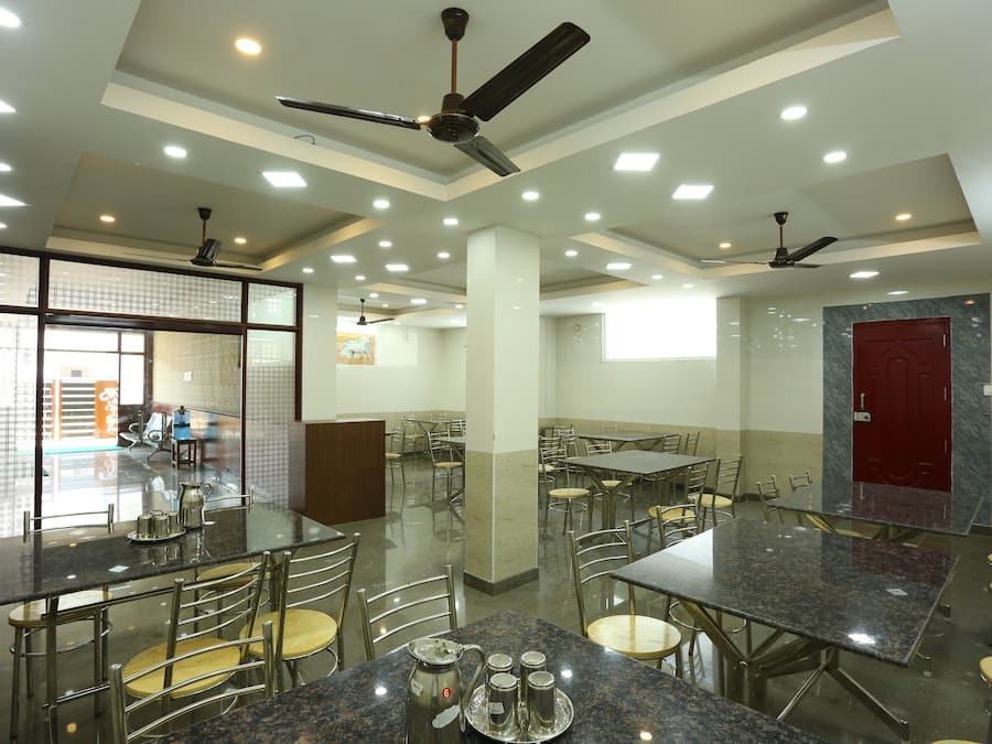 Un'ampia sala da pranzo con diversi tavoli e sedie, ventilatori a soffitto e illuminazione a incasso.