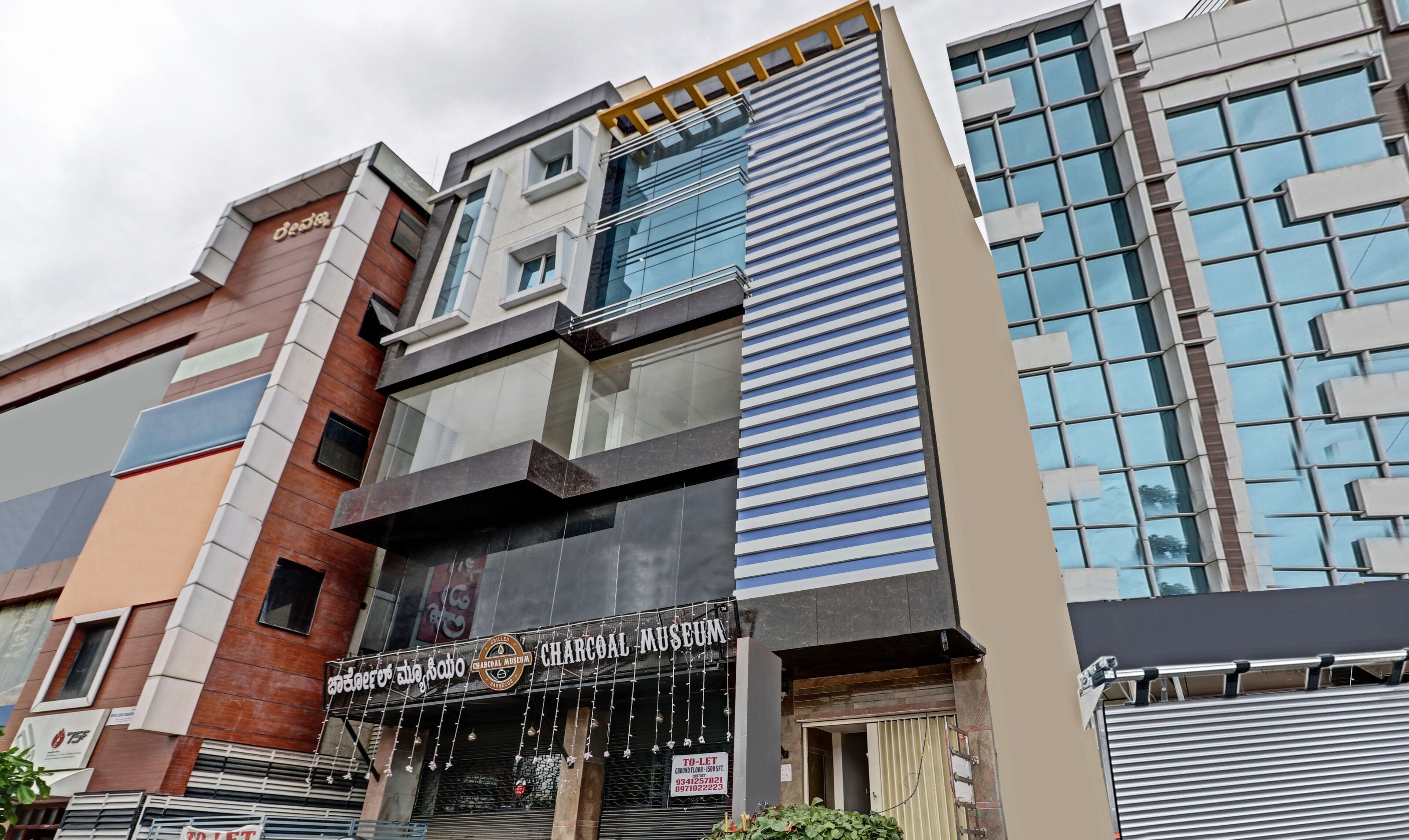 A building with a Charcoal Museum sign, modern architecture, and a ground floor to-let sign.