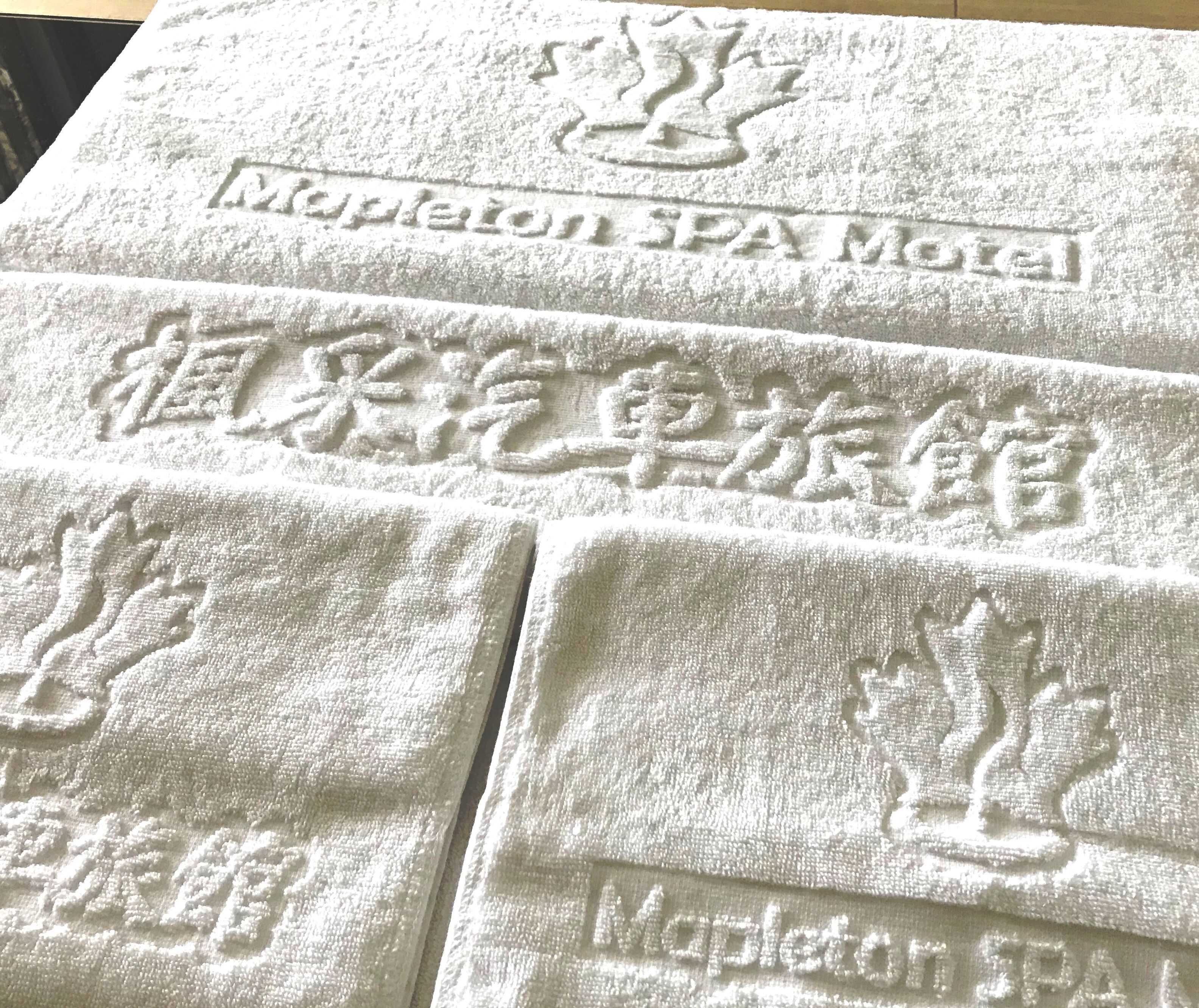 Una toalla con el nombre "Mapleton SPA Motel" grabado.