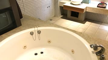 Een badkamer met een groot bad, een wastafel en een spiegel.