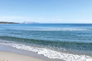 A beach with clear water and a distant mountain. - Apartment in Tanaunella Budoni with Pool (Tanaunella - Budoni (SS))