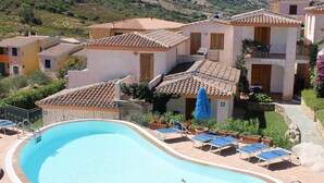 Une piscine avec des chaises longues et un chemin pavé de pierres.