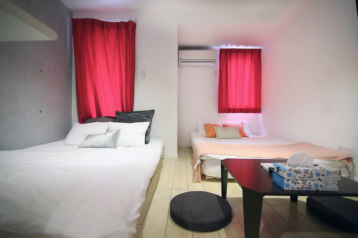 Ein Hotelzimmer mit zwei Betten, einem kleinen Tisch und einem Schreibtisch mit Stuhl.