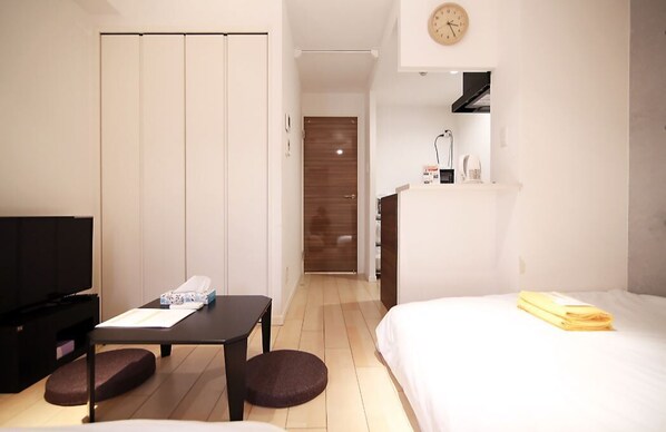 Ett hotellrum med en säng, en TV, ett skrivbord och en garderob.