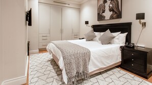 A neatly arranged bedroom with a bed, bedside tables, and a wardrobe. - Unit Number 620 Cape Royale Luxury Apartments (Cape Town)