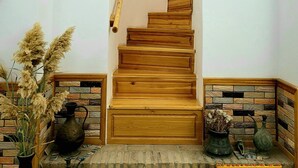 Una escalera de madera con base de pared de piedra que conduce a un piso superior.