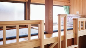 A wooden bunk bed with a mattress and a wooden headboard. - Hanareya (Tsushima)