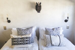 A double bed with patterned pillows and two wall-mounted light fixtures. - The Farmstead Franschhoek (Franschhoek)