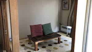 A room with a tatami mat floor, a low wooden table with cushions, a sliding door, and a radiator. - Alpha Lodge Madarao (Myoko)
