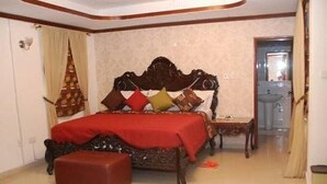 Ein Schlafzimmer mit einem großen Bett, einem kleinen Tisch und einem Stuhl.