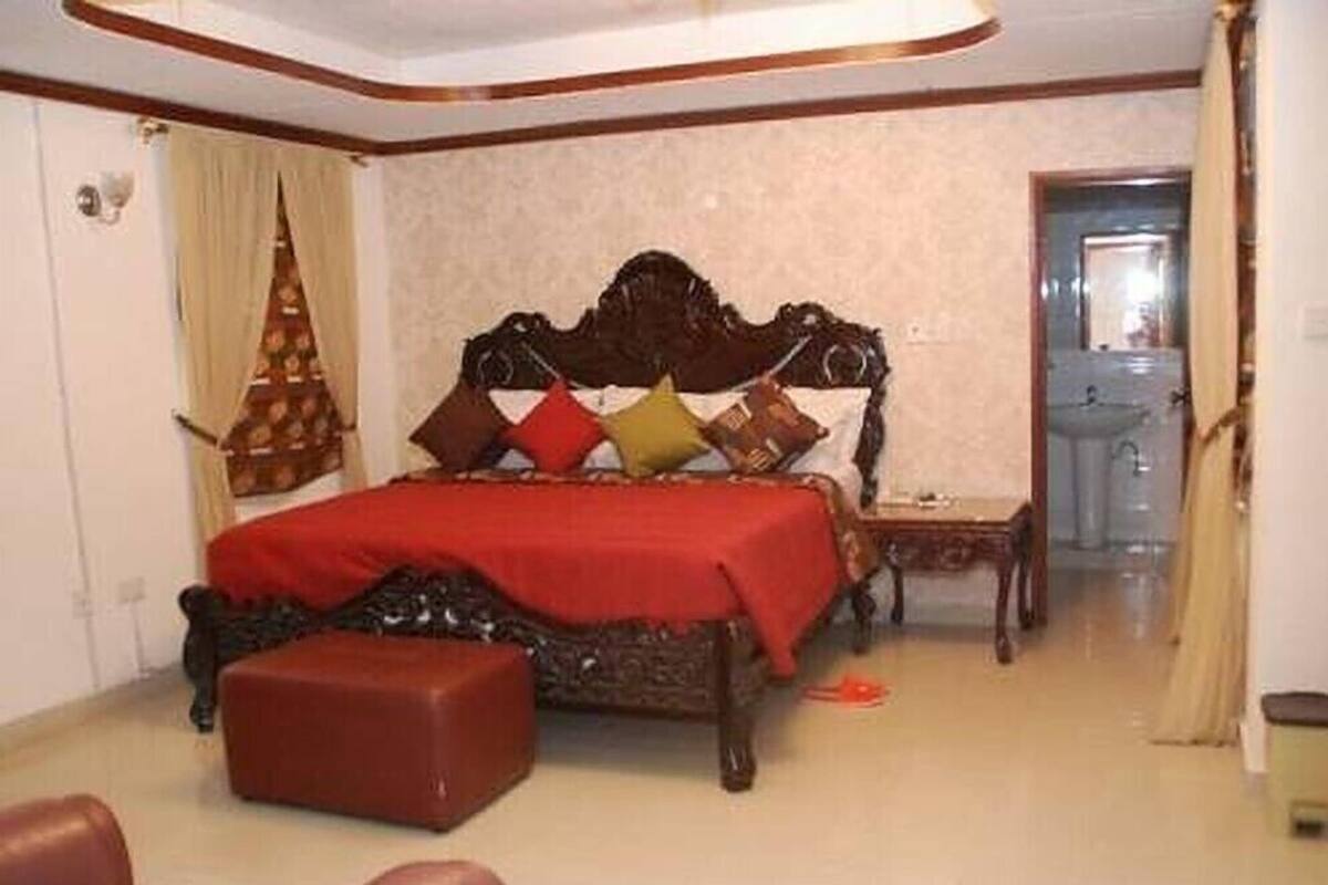 A bedroom with a large bed, a small table, and a chair.